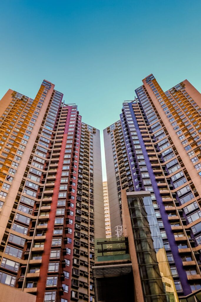 Tall, colorful skyscrapers reaching into the blue sky in Hong Kong, showcasing modern architecture.